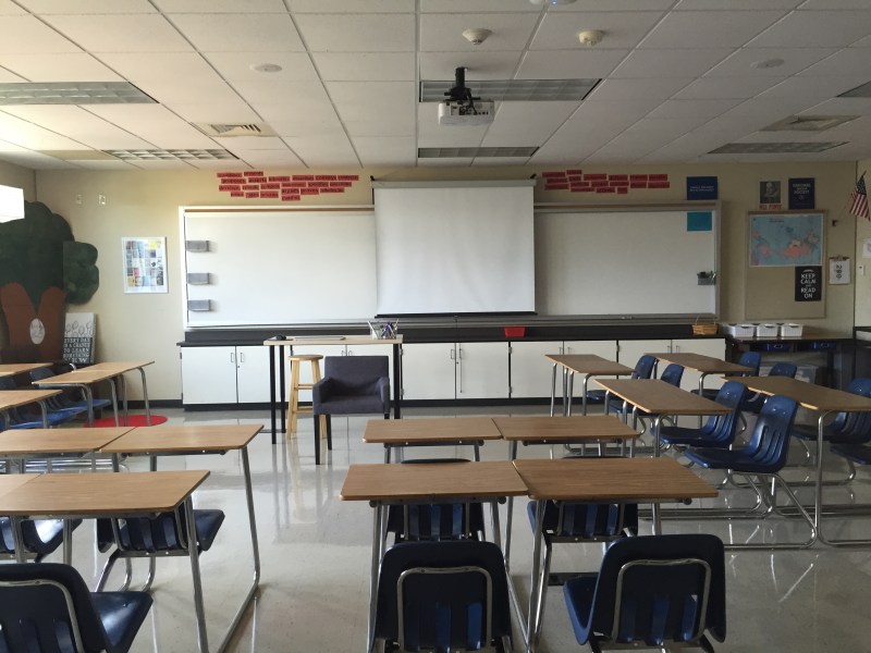 The front of my classroom. The red signs above the board are strong verb reminders for my AP Lang students. Eventually, I'm going to add Kelly Gallagher's 6 Reasons for Writing to the front cabinets.